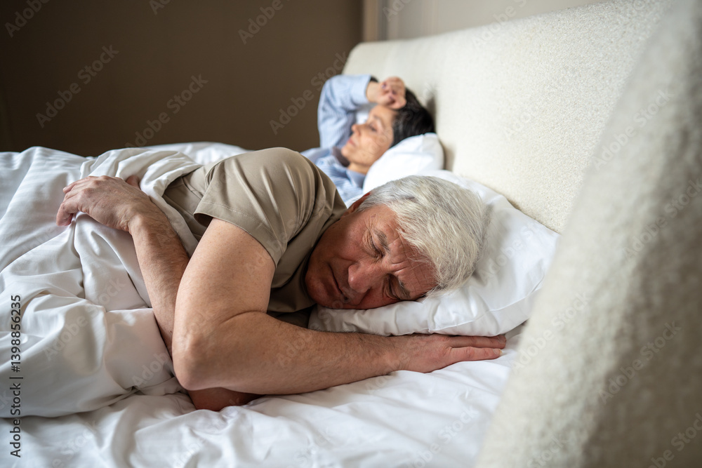 Unhappy mature couple wife and husband sleep fitfully after heated argument remaining tense in shared bed. Relationship conflict, unresolved anger, emotional distance, troubled sleep, marital strain Unhappy mature couple wife and husband sleep fitfully after heated argument remaining tense in shared bed. Relationship conflict, unresolved anger, emotional distance, troubled sleep, marital strain