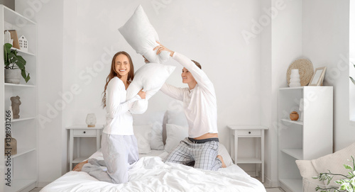 Young couple fighting pillo...