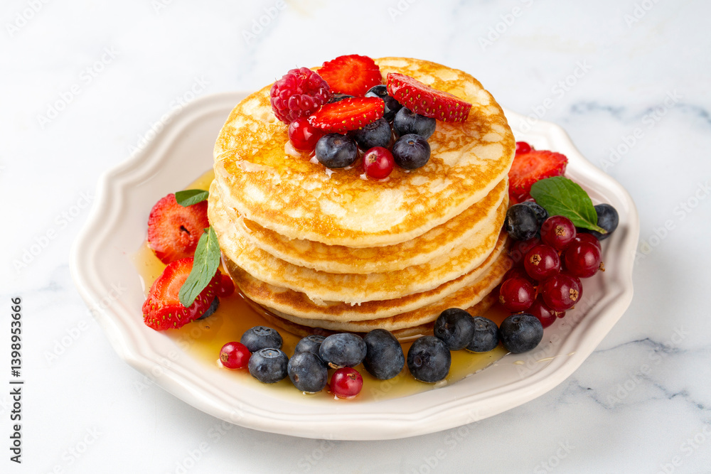 Healthy summer breakfast, homemade classic american pancakes with fresh fruit and honey, morning light gray stone background copy space top view