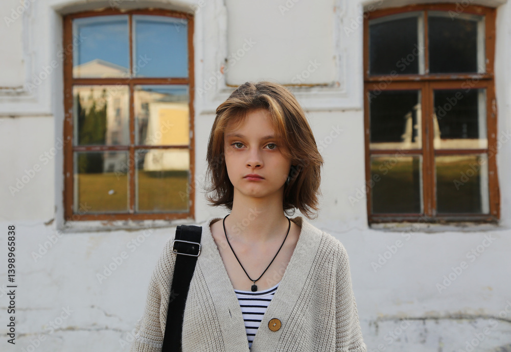 Thinking teen girl with shot hair standing front in casual clothes outdoors summer houses windows background. Fashion style emotional closeup people portrait Thinking teen girl with shot hair standing front in casual clothes outdoors summer houses windows background. Fashion style emotional closeup people portrait