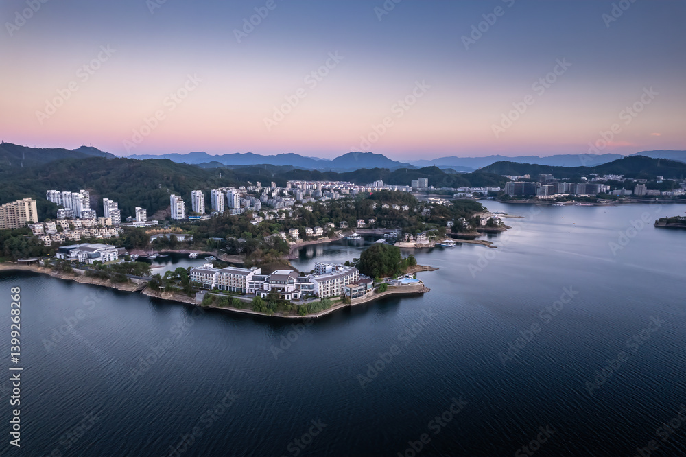 Naklejka premium Serene Lakefront View with Mountains and Modern Architecture at Dawn