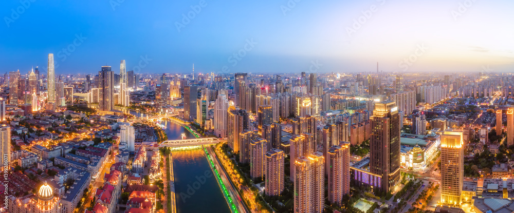 Stunning Urban Cityscape at Dusk with Vibrant Lights and Waterway