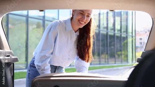Young businesswoman putting her luggage in the car trunk before going to the airport for a business trip