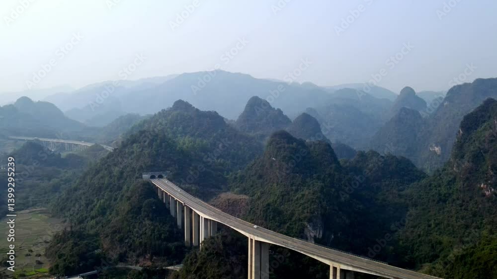Aerial view of elevated highway in Guangxi's mountainous landscape Aerial view of elevated highway in Guangxi's mountainous landscape