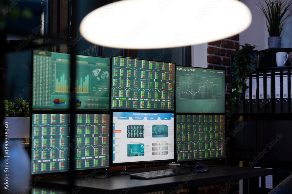 Empty desk with multi screens displaying forex charts, ready for the team to begin trading in modern, tech savvy workplace. Desktop monitors showing financial data, prepared for night shift workers
