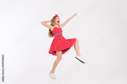 Obraz na płótnie Cheerful young woman dancing in a vintage red polka dot dress, showcasing retro style and vibrant energy on a white background w salonie