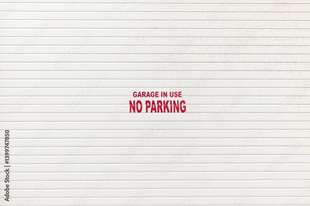 White garage door with a notice - garage in use no parking