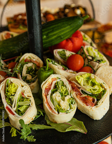 Fresh wraps with lettuce, tomatoes, and cucumbers stacked vertically.