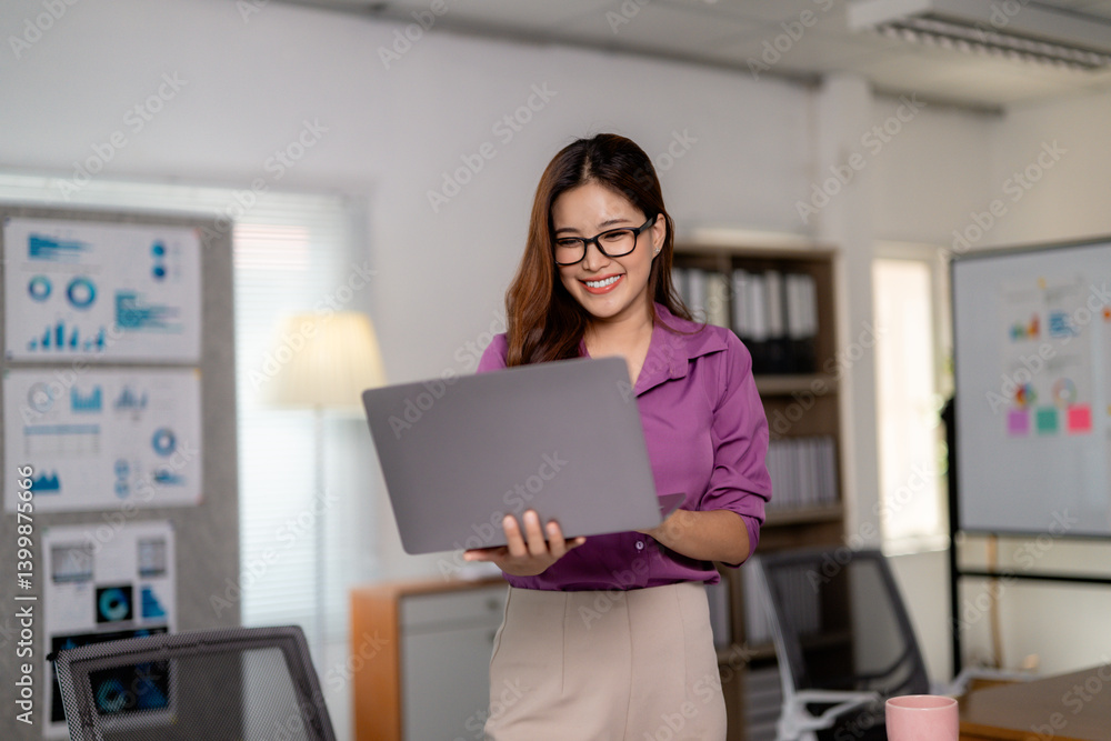 Smiling businesswoman holding laptop and working in modern office Smiling businesswoman holding laptop and working in modern office