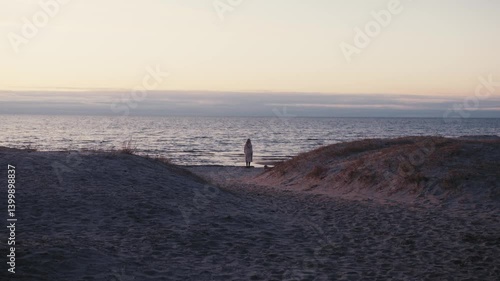 Wallpaper Mural Woman Stands by the Sea at Twilight, Framed by Windswept Sand Dunes Torontodigital.ca