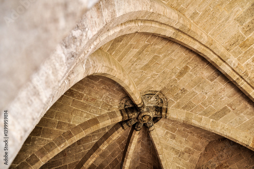 Fotografie Historic vaulted stone ceiling with central keystone and radial arch ribs viewed