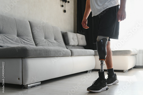 Fotografie Man amputee with prosthetic leg disability on above knee transfemoral leg prosthesis artificial device at home