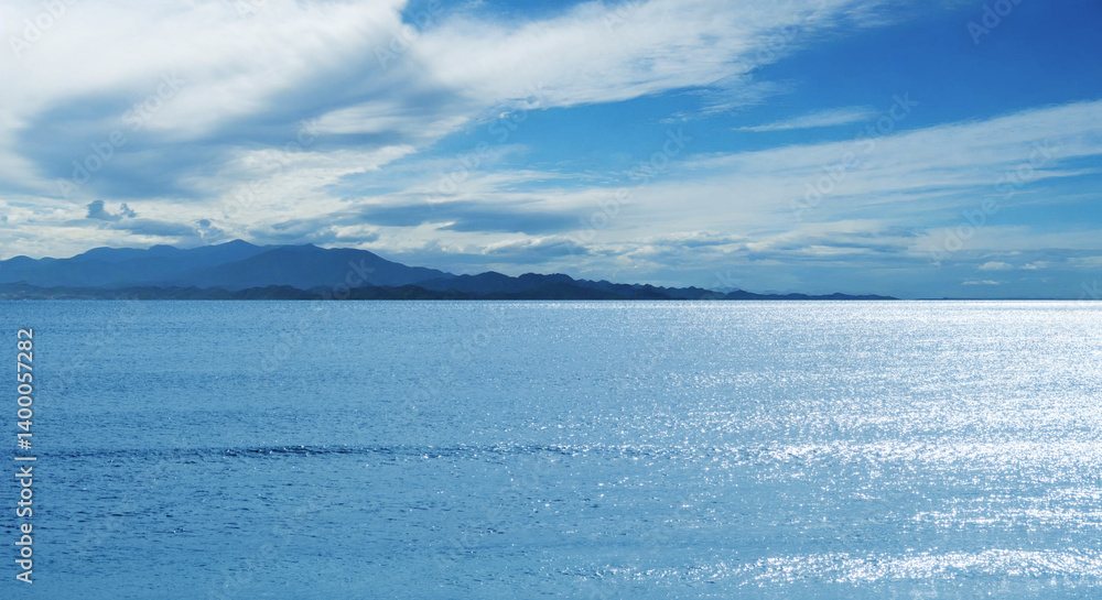 Obraz premium 青い空と輝く海 青空に浮かぶ夏の積雲 風に流れる雲の風景 キラキラ輝く波の背景 夏休み・アウトドア・観光・旅行・行楽・バカンスのイメージ