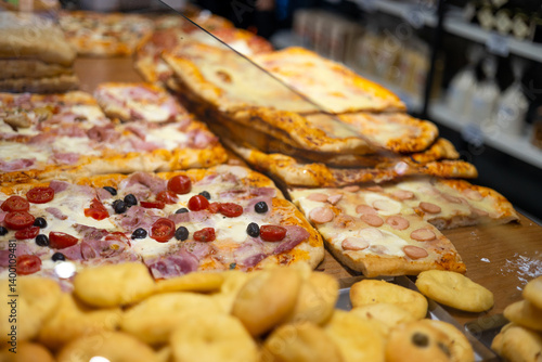 Obraz na płótnie Authentic Italian pizza in a restaurant display window in Italy. Various pizzeria in glass window display. w salonie