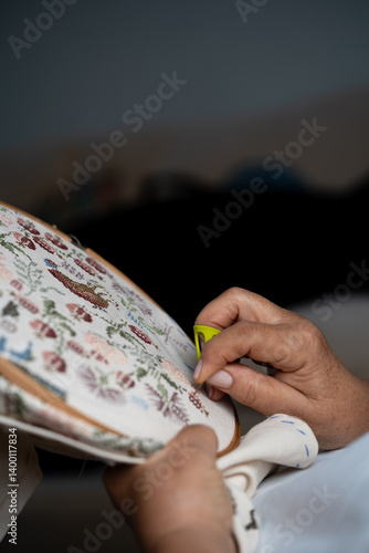 Εκτύπωση καμβά Senior woman embroidering a floral pattern using a needle threader