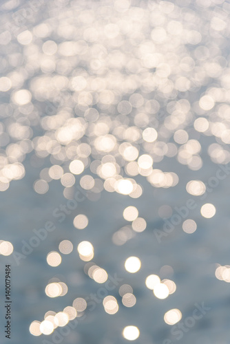 Circular light spots on the water surface. The river in bokeh. Dreamy blue background.