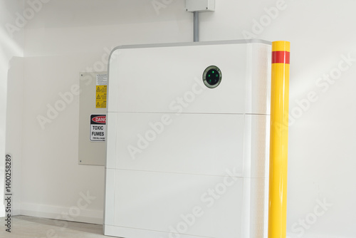 16Kw Solar battery home storage unit in a garage with yellow safety bollard and warning signs