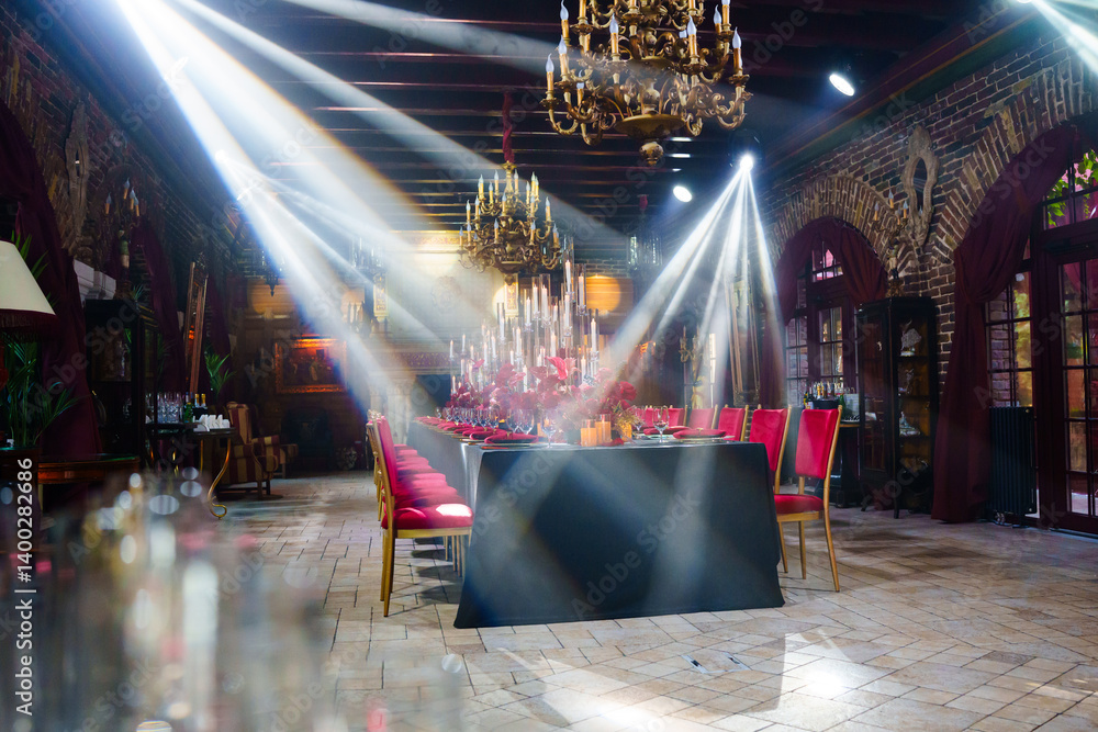 Spotlights in the banquet hall of a dark restaurant.