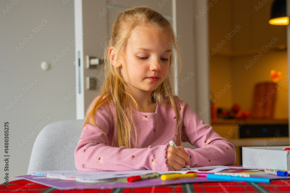Young child engages in creative drawing activity at home in a cozy setting during the afternoon