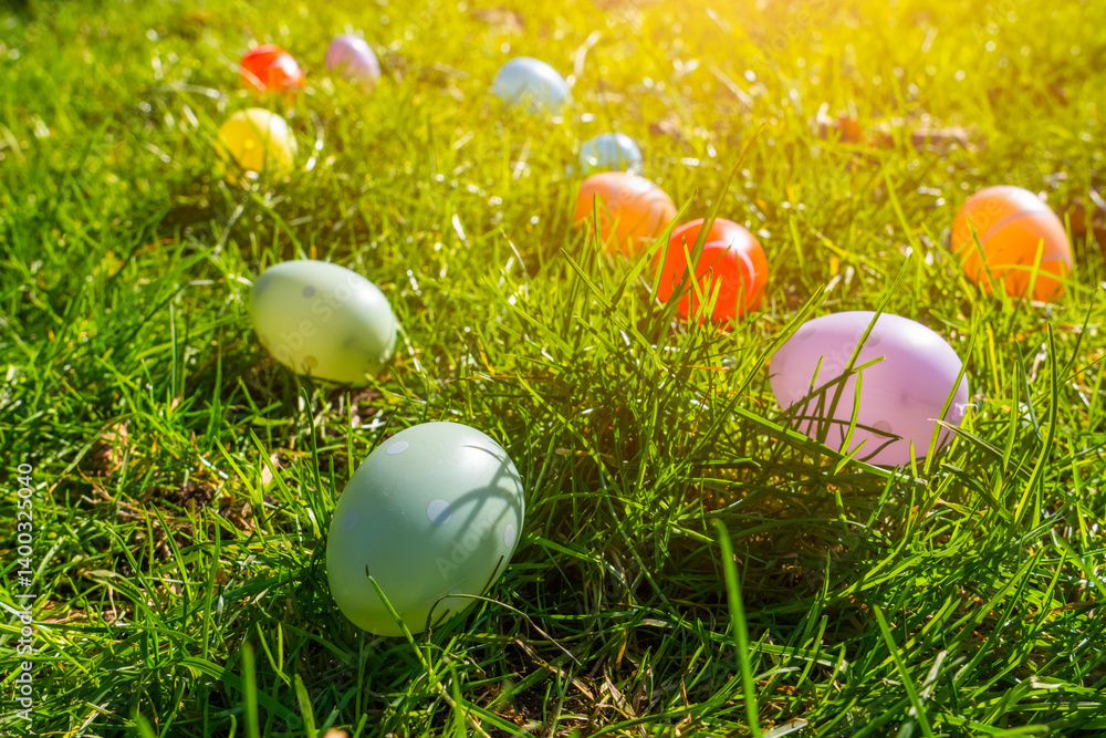 Colorful plastic eggs scattered on green grass during a sunny afternoon celebration