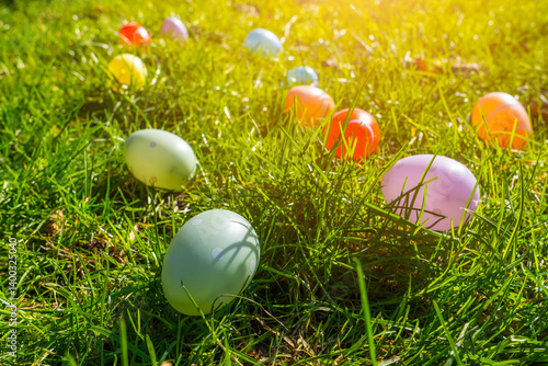 Obraz na płótnie Colorful plastic eggs scattered on green grass during a sunny afternoon celebration w salonie