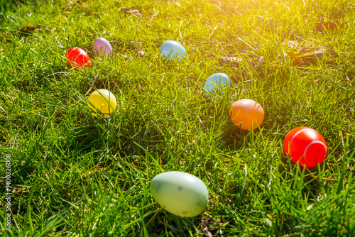 Obraz na płótnie Colorful Easter eggs scattered on green grass during a sunny spring day in the park w salonie