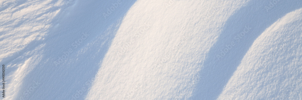 Snow texture. Wind sculpted patterns on snow surface. Wind in the tundra and in the mountains on the surface of the snow sculpts patterns and ridges. Arctic, Polar region. Winter panoramic background.
