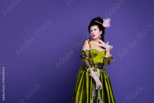 Fotografie Elegant woman in green historic costume with purple background showcasing baroqu