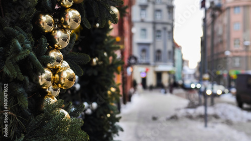 Canvas Print Golden christmas balls decorating a christmas tree on a blurred city street