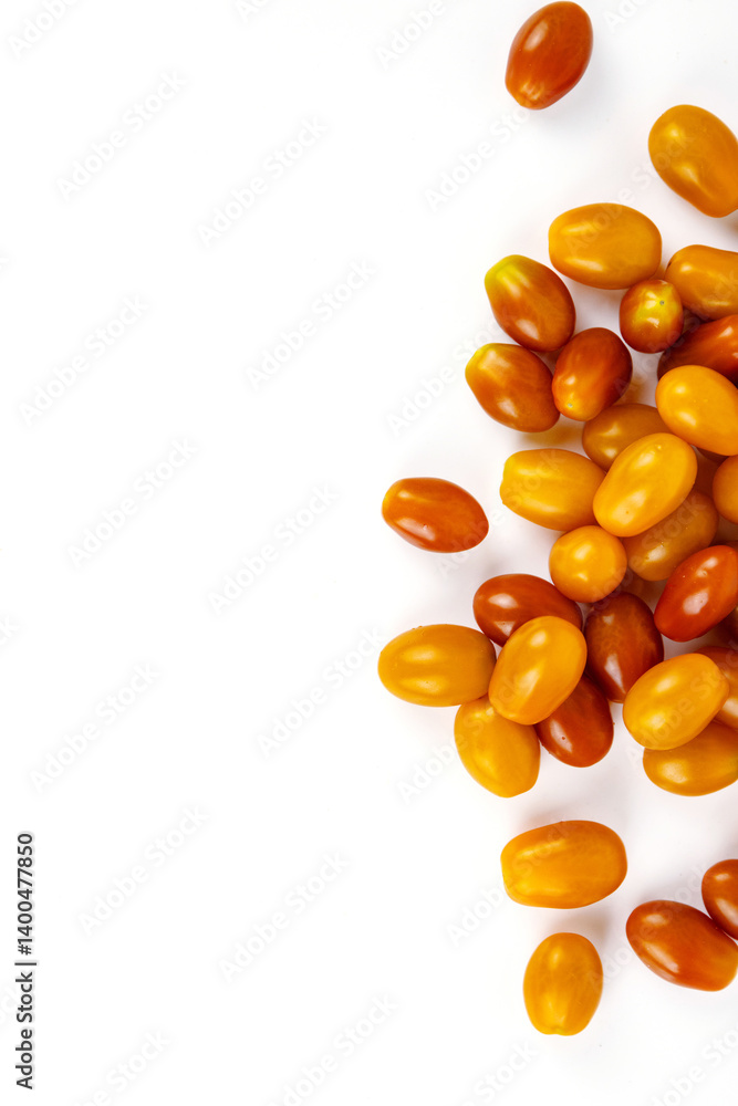 Fototapeta premium Top view of fresh yellow and orange cherry tomatoes scattered on white background. Isolated on clean white backdrop. Food, health, and organic nutrition concepts. Copy space 