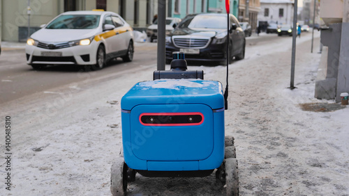 Photography Autonomous delivery robot moving on a snowy sidewalk, navigating urban environment in Moscow