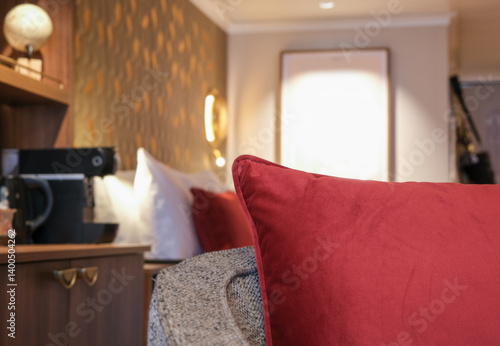 Luxurious mini suite stateroom cabin room onboard luxury cruise ship cruiseship ocean liner with bedroom and living area in red and creme with wood in modern Art Deco interior design