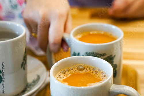 Popular drink in Malaysia called Teh Tarik. It is a sweet drink made from tea with milk. Fractal on the cup is generic print.