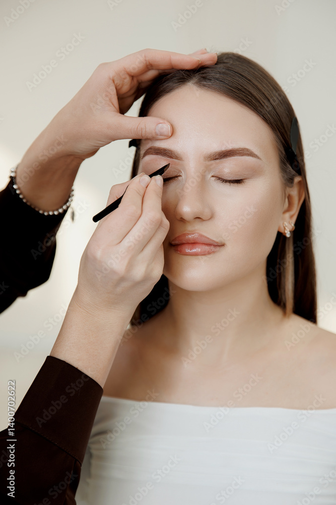 Fototapeta premium Female beautician tinting caucasian woman eyebrows with precision