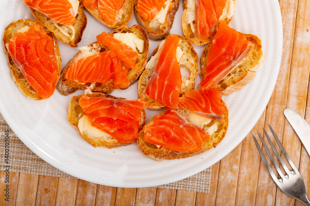 Delicious sandwiches with bread, smoked salmon and butter on a table in a cafe Delicious sandwiches with bread, smoked salmon and butter on a table in a cafe