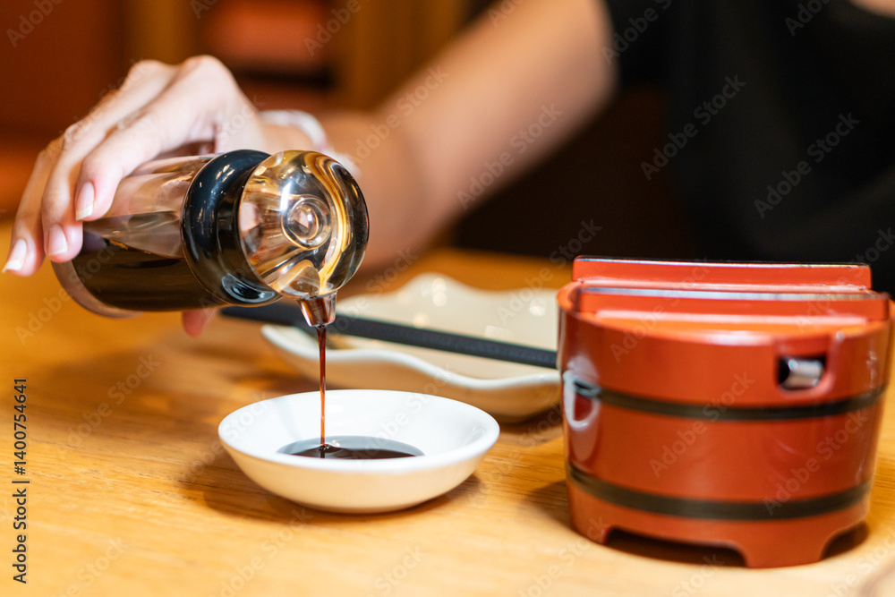 Pouring Soy Sauce in a Dining Setting Pouring Soy Sauce in a Dining Setting
