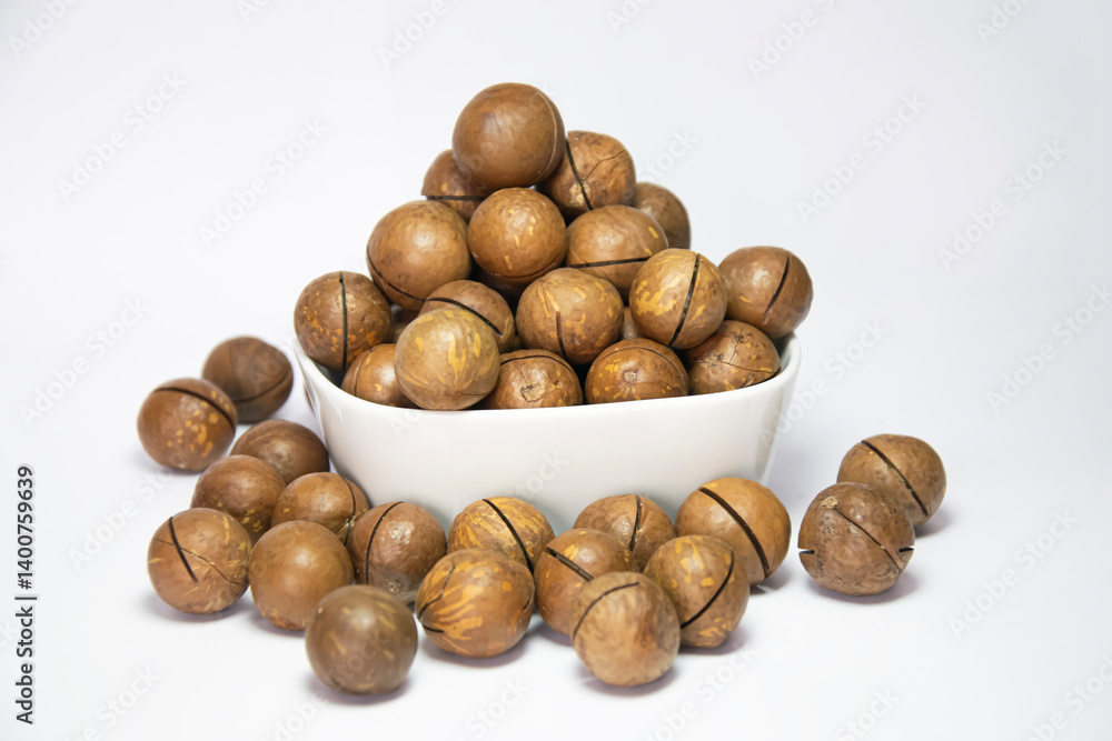 Macadamia nuts in white cup on white background Macadamia nuts in white cup on white background