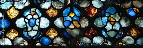 Stained glass window with floral patterns in blue yellow white and brown colors.