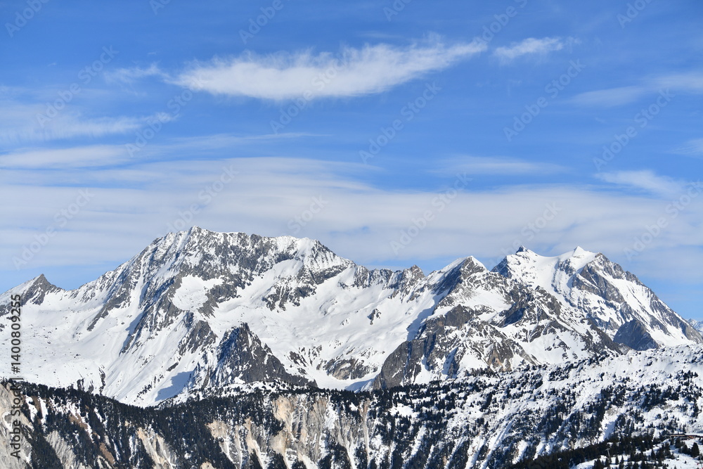 Obraz premium French alps on a sunny day under the clouds by winter covered with snow