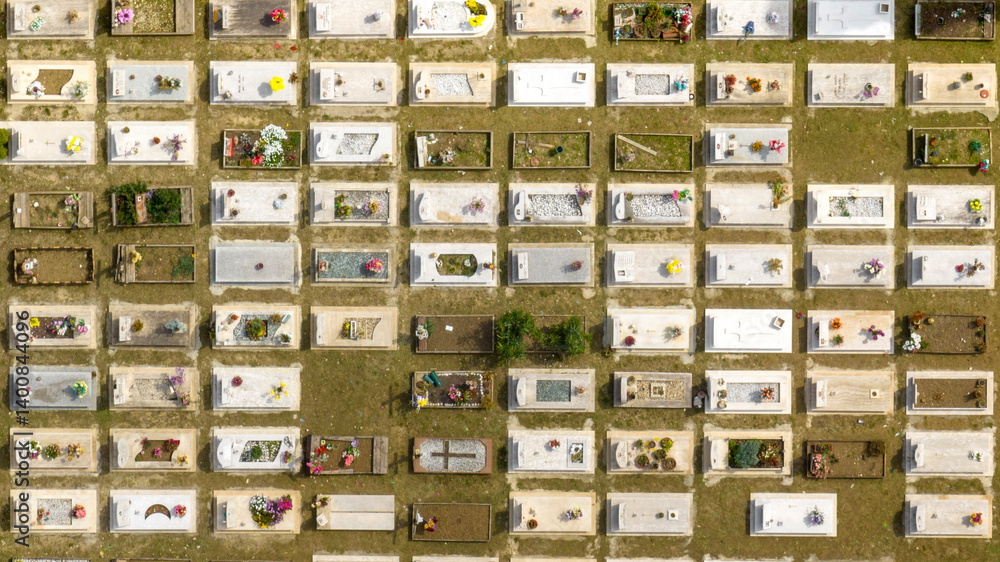 Aerial perpendicular view of graves in a meadow in a cemetery.