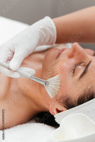 Cosmetology beauty procedures. Lady receiving rejuvenation anti aging treatment, facial chemical peel therapy in beauty salon or medical center. Wellness. Mask with retinol. Close-up, ads