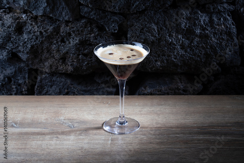 Espresso Martini cocktail with coffee beams and bubbles, on lava stones background
