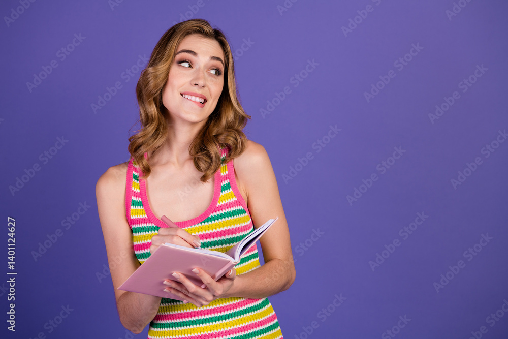 Young Woman Smiling While Holding Notebook Against Clean Purple Background in Casual Summer Attire Young Woman Smiling While Holding Notebook Against Clean Purple Background in Casual Summer Attire