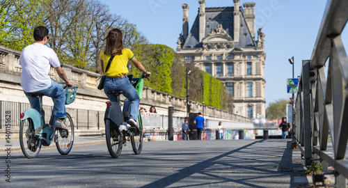 Canvas Print Une jeune fille et un jeune homme à Paris en vélo.