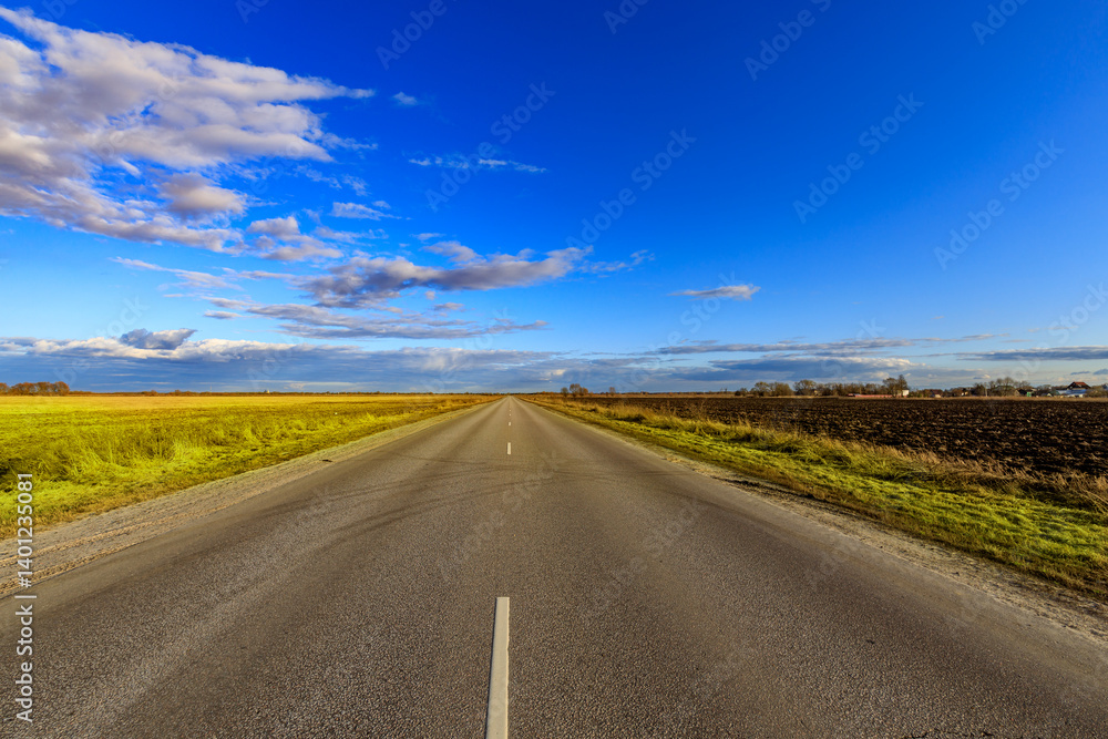 Fototapeta premium A long, empty road with a clear blue sky above