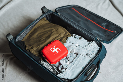 A large suitcase that is packed with an assortment of clothes along with a wellstocked first aid kit for any medical needs that may arise during your travels or adventures