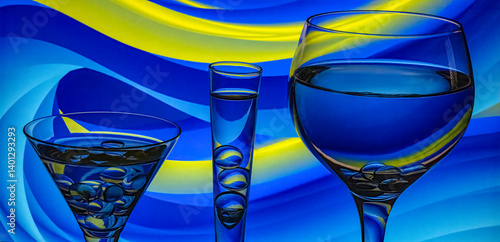 Glasses with water and blue and yellow background