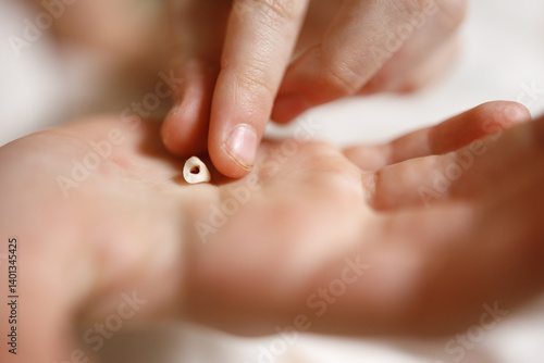 the child's fingers touch the milk tooth in the palm of the hand