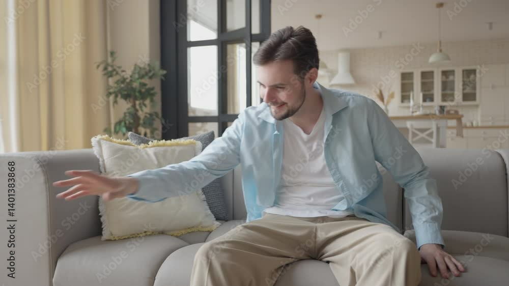Student Sitting On Sofa, Picking Up Controller And Starting A Video Game Session Student Sitting On Sofa, Picking Up Controller And Starting A Video Game Session