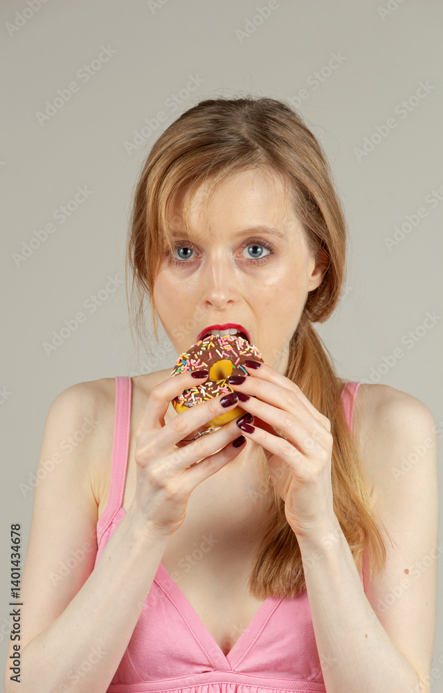Young beautiful girl with unhealthy eating habits having a chocolate donut Young beautiful girl with unhealthy eating habits having a chocolate donut
